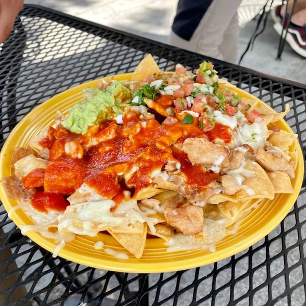 Sancho's Taqueria nachos with chicken, red sauce, melted cheese, guacamole, and pico de gallo.